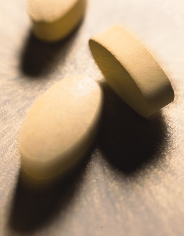 medicine pills lie on a light surface and cast shadows