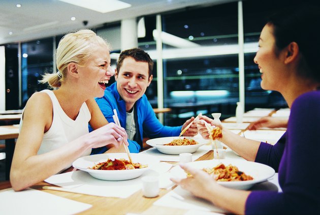 Three People Enjoying a Meal in a Chinese Restaurant