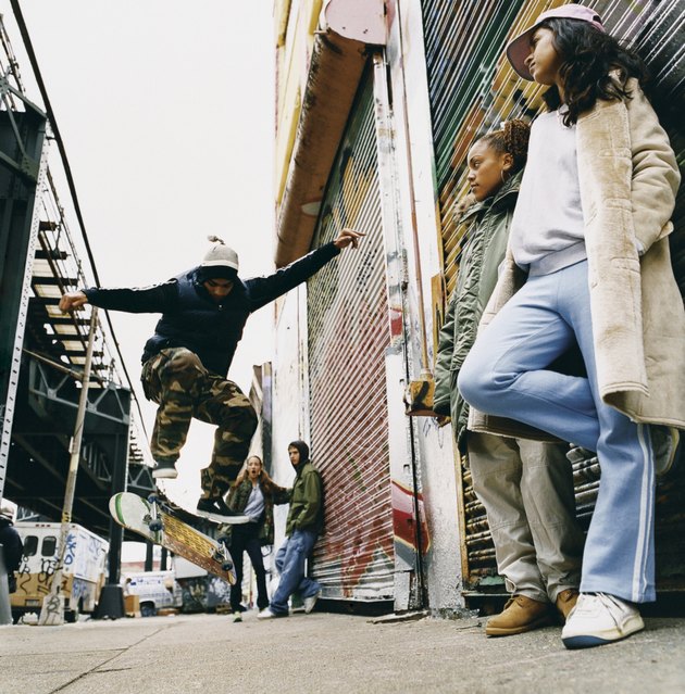Medium Group of Teenagers in a Back Alley Watching Stunts on a Skateboard
