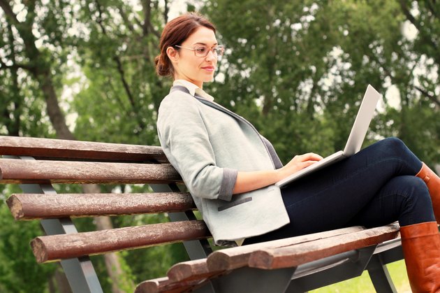 Woman in park with laptop