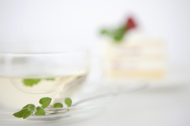 Herbal tea with cake in the background
