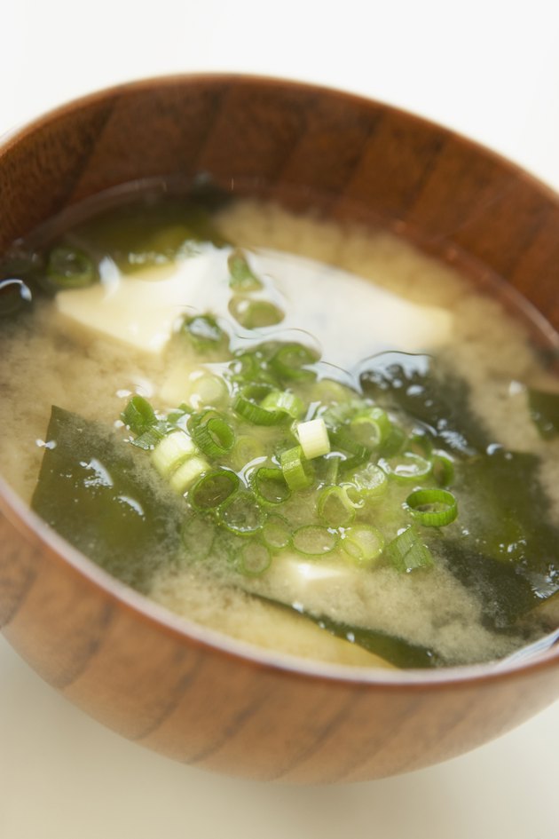 Tofu and seaweed in Miso soup, close up, white background