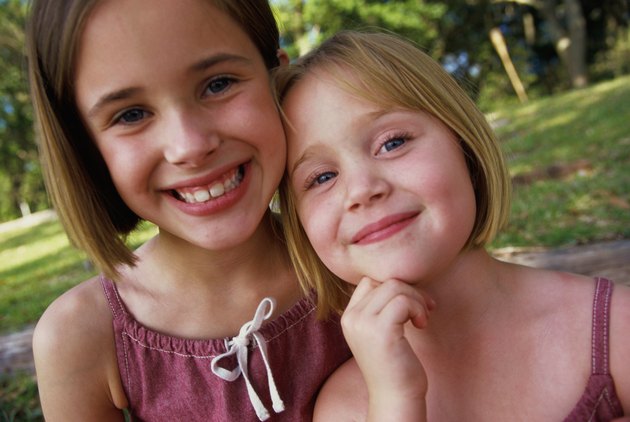 Portrait of two girls (4-5,8-9) smiling