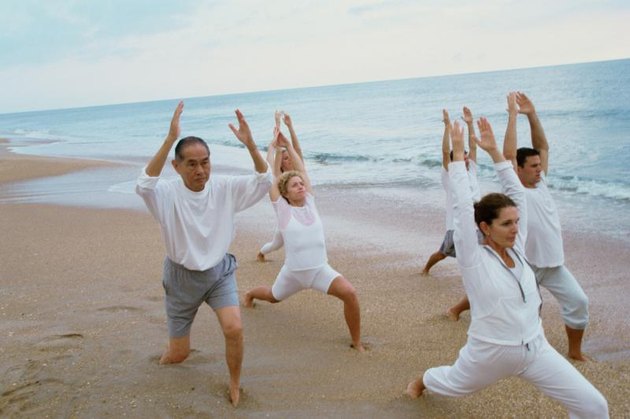 group of people meditating by the sea