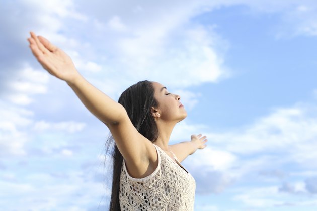 Portrait of arab woman breathing fresh air with raised arms