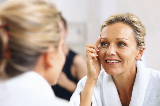 Beautiful mature woman admiring herself in the mirror