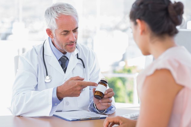 Doctor explaining the bottle of pills to patient