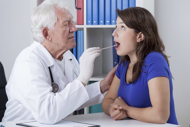 General practitioner examining throat