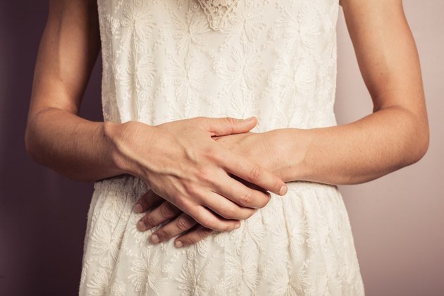 Young woman in white dress with stomach pains