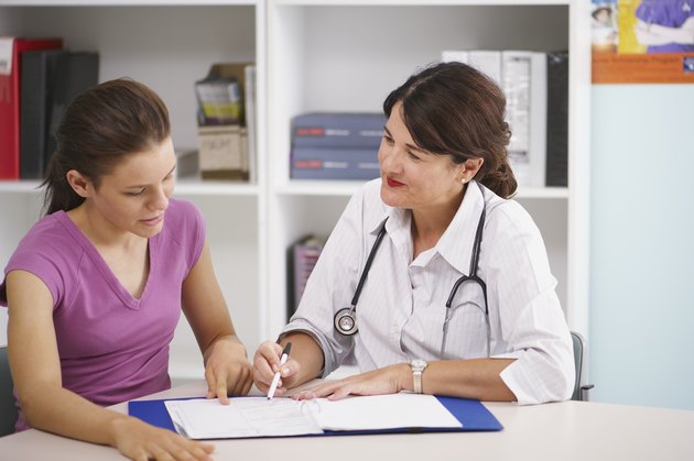 Doctor writing in patient's chart
