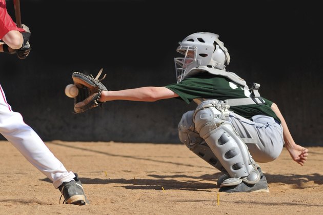 Teen boy plays baseball catcher