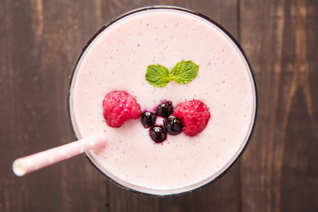 Raspberry and blueberry smoothie on wooden background.