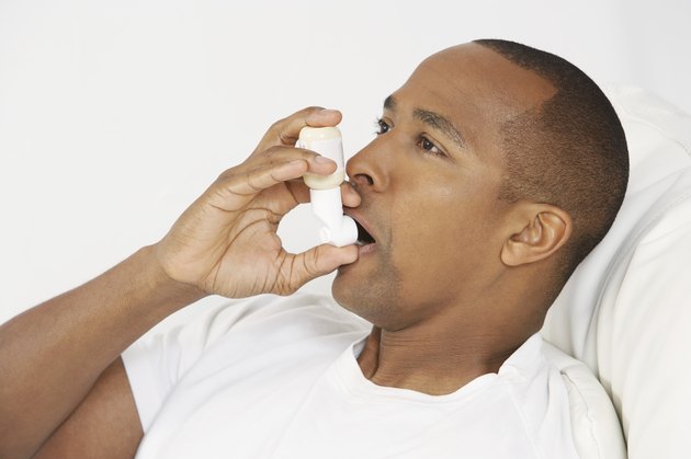Man using inhaler in hospital bed