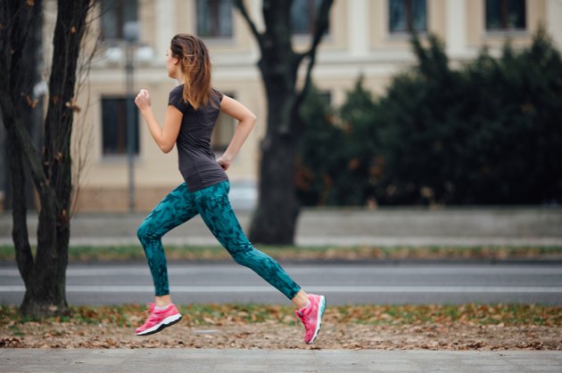 Young girl running outdoors in a city park