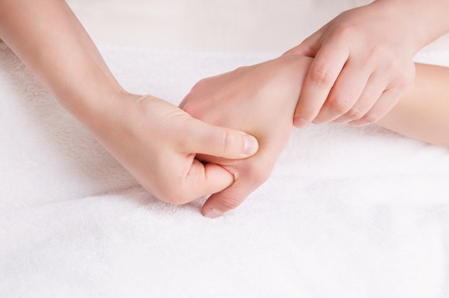 Therapist doing a pressure point massage on the womans hand