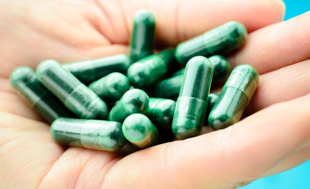 Green medical pills on hand