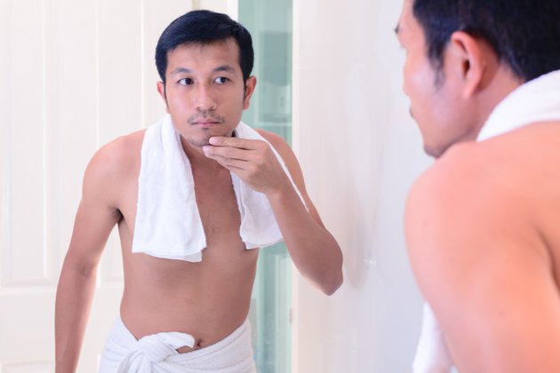 Young handsome man touching his beard face before shaving.