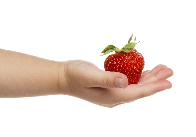 Child's hand with strawberries.