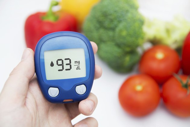 Diabetes doing glucose level test. Vegetables in background