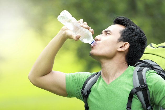 thirsty man drinking a bottle of water