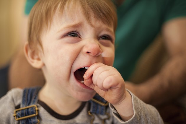 Adorable blond baby crying at home