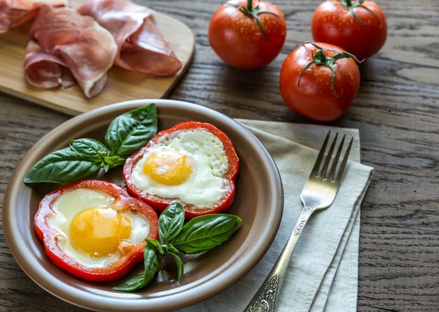 Fried eggs with prosciutto on the wooden table