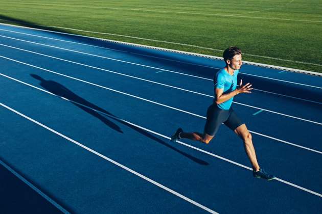 Young male athlete training on a race track