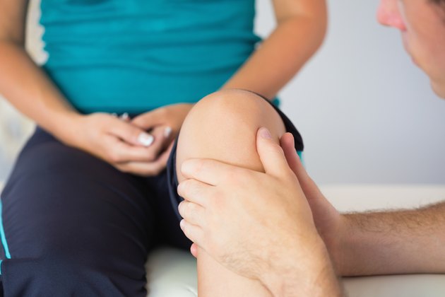 Physiotherapist checking patients knee