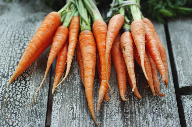 Fresh organic carrots on wooden background, selective focus