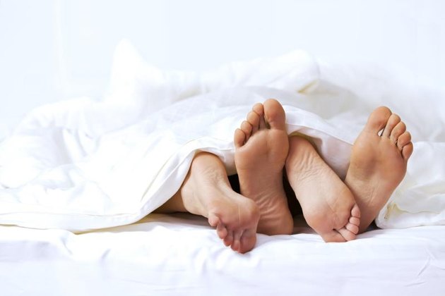 Close-up of the feet of a couple on the bed