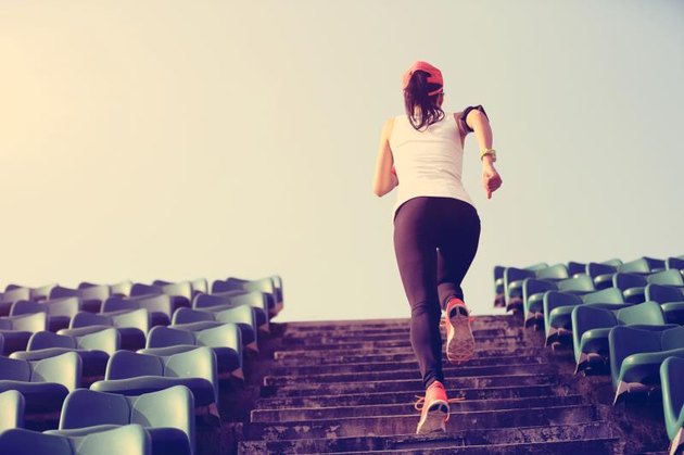 Runner athlete running on stairs. woman fitness jogging workout wellness concept.