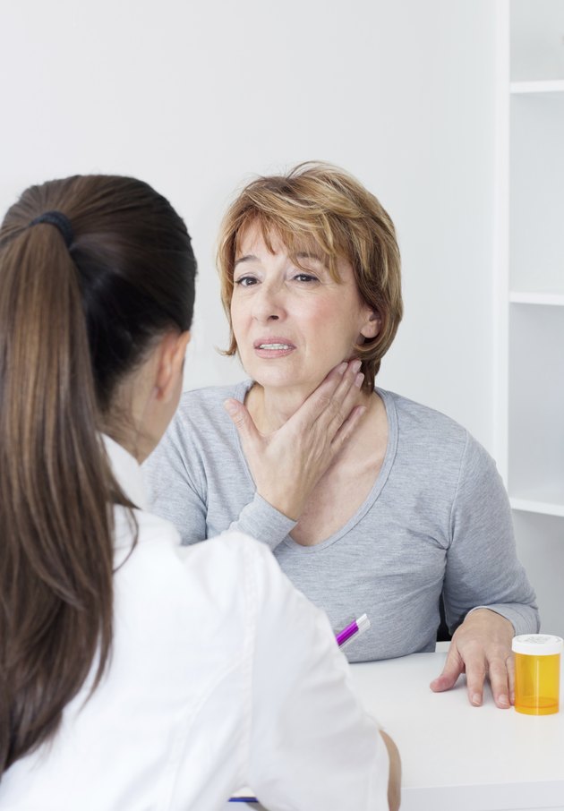 Women with hand on her neck experiencing sore throat