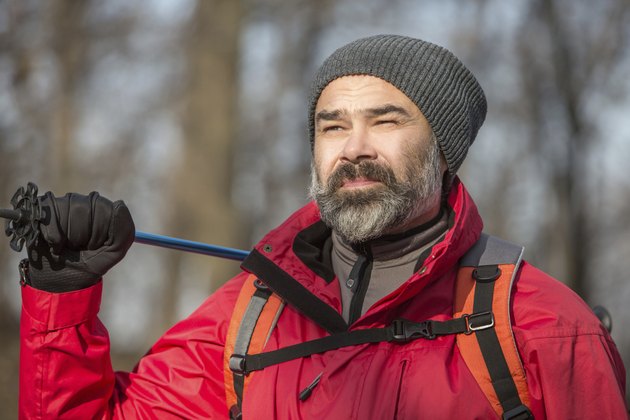 Portrait of hiker man with backpack and trekking pole