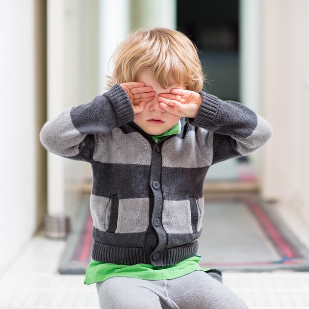 Little kid boy crying at home and showing sad mood