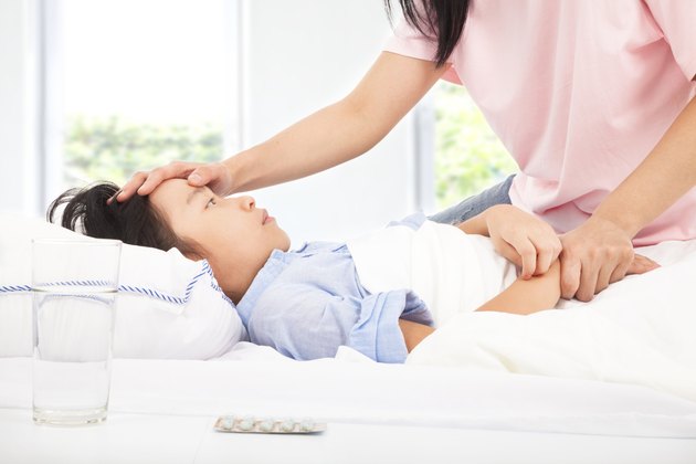 Mother checking temperature of sick daughter by hand