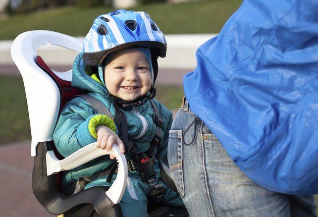 Cheerful little boy in a bike seat