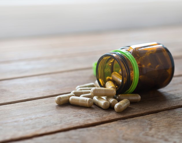 Herb capsule spilling out of a bottle