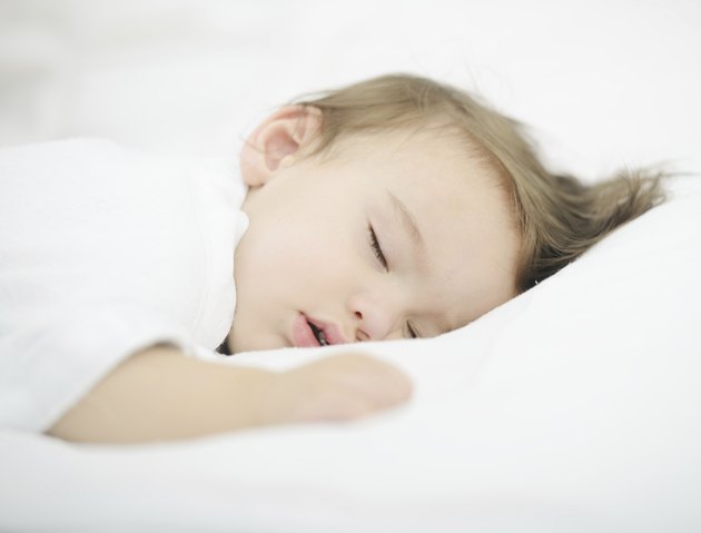Baby sleeping on white bed