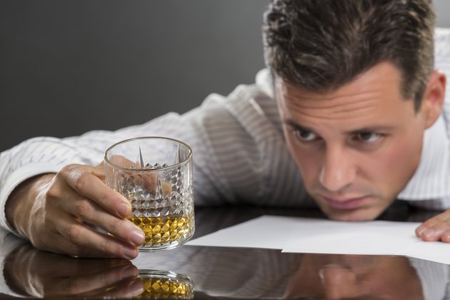 Sad businessman drinking alcohol