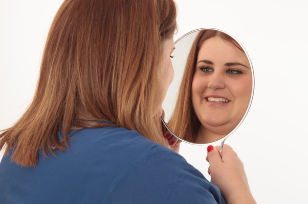 Smiling woman looking herself in a mirror