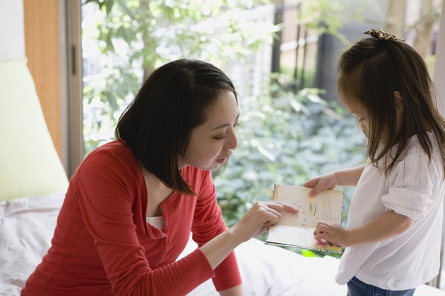 Mother Reading Picture Book for Daughter