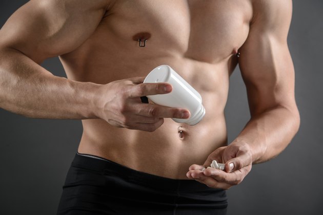 Muscular Man Taking His Supplement Pills