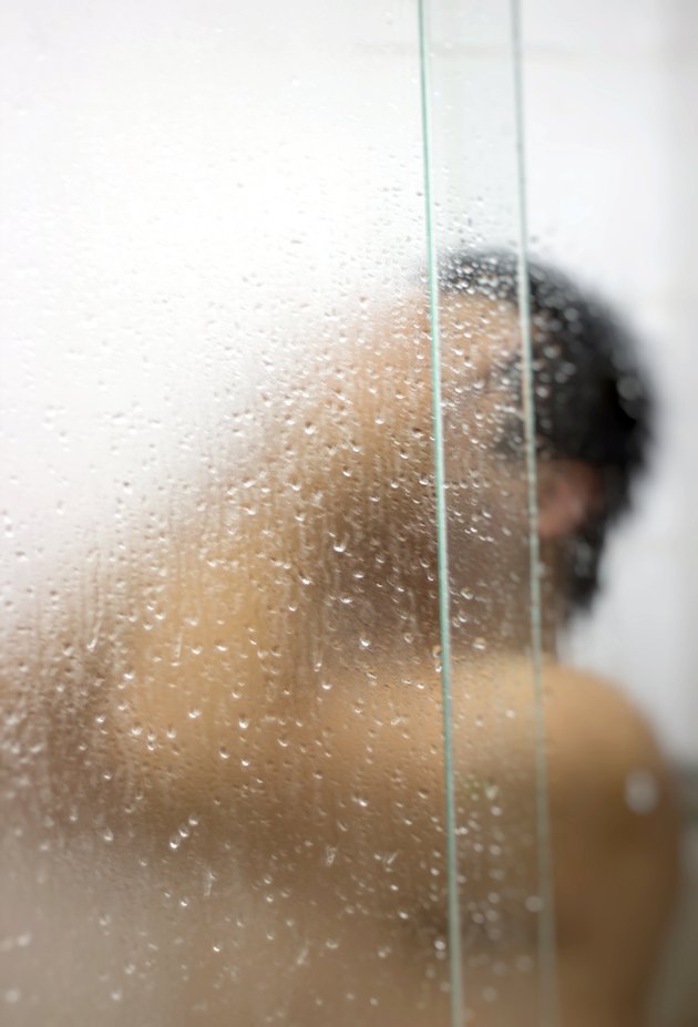 Man bathing in the bathroom stall.