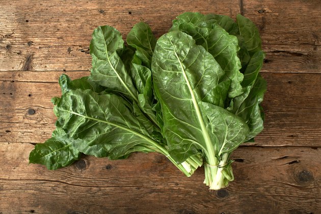 bunch of fresh spinach on wooden table