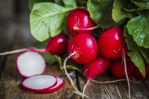 Radishes on rustic wooden background