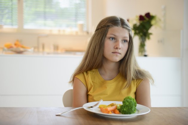 Girl looking bored with healthy meal