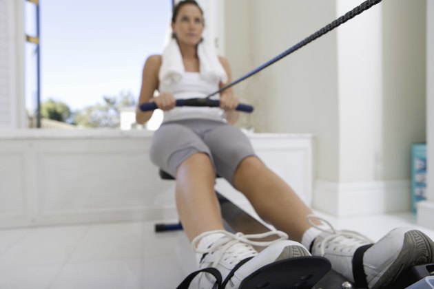 Young woman on rowing machine, low angle view