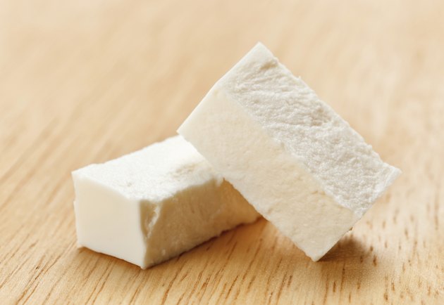 Feta cheese cubes with on wooden chopping board