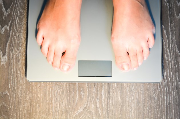Lose weight concept with person on scale measuring kilograms