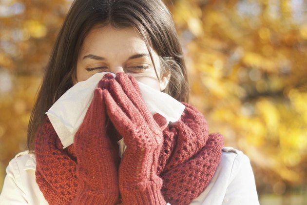 Woman with tissue having flu or allergy